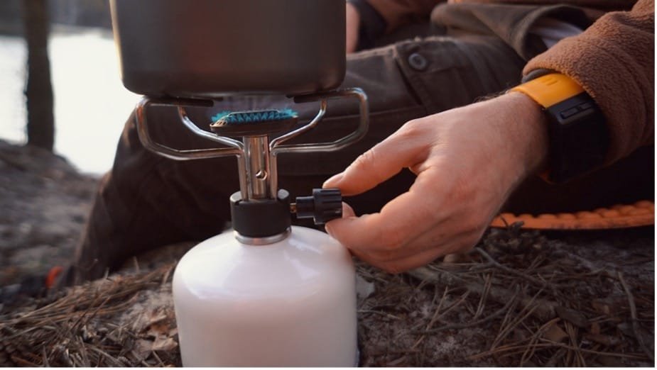 A person's hand setting up a gas cylinder
