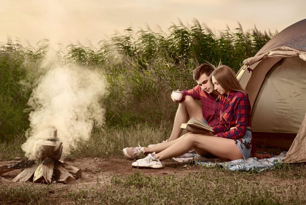 Young happy couple resting on nature with tent. Vintage Filter.